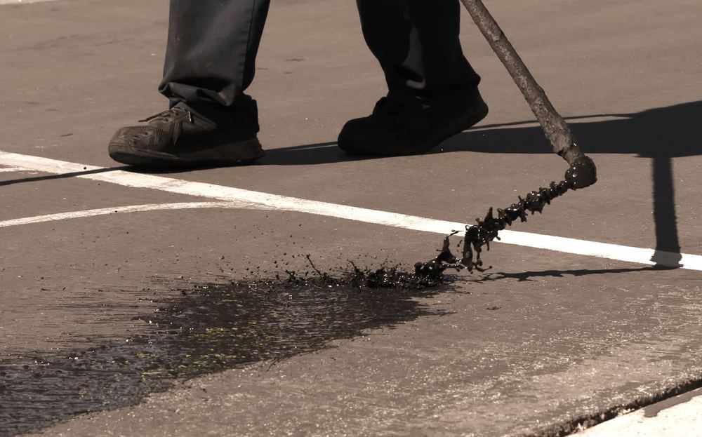 Sealcoat being applied to asphalt